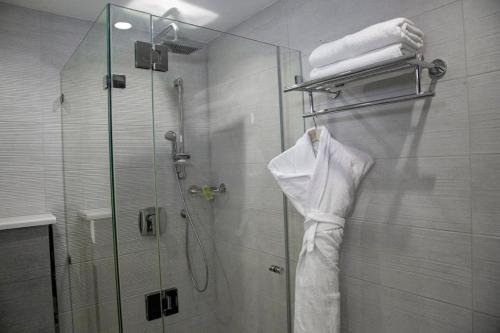 La salle de bains est pourvue d'une douche avec une porte en verre. dans l'établissement Seas Hotel Amman, à Amman