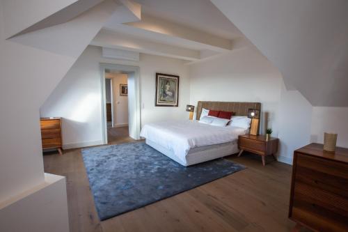 ブダペストにあるZOYA LUXURY RESIDENCEのベッドルーム(白いベッド1台、青いラグ付)