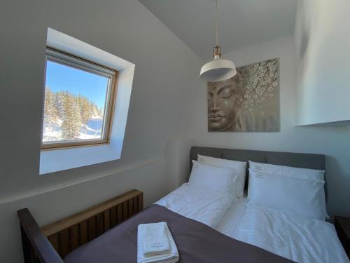a bed in a room with a window and a bed sidx sidx sidx at Nivalis Residence Jahorina in Jahorina