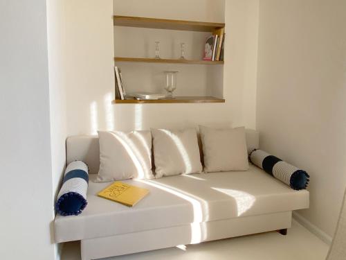 a white couch with pillows and a book on it at Villa Lina in Tremezzo