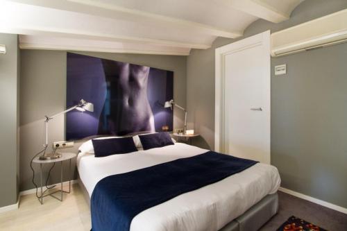 バレンシアにあるBoutique Alma Apartmentsのベッドルーム1室(壁に絵画が描かれた大型ベッド1台付)