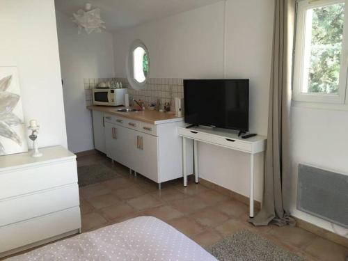 een keuken met een tv op een bureau en een wastafel bij Studio indépendant in Balaruc-les-Bains