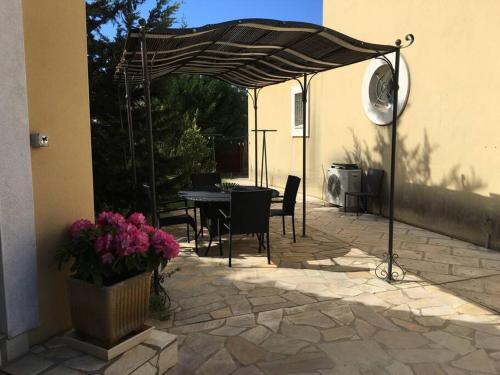 een patio met een tafel en stoelen en een parasol bij Studio indépendant in Balaruc-les-Bains