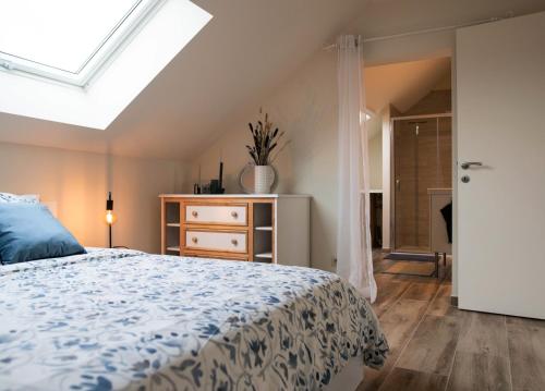 een slaapkamer met een bed en een dakraam bij La Brume des Abbayes in Mettet
