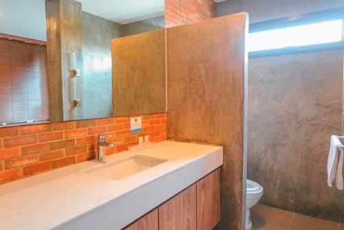 a bathroom with a sink and a mirror and a toilet at V20 Boutique Jacuzzi Hotel in Bangkok