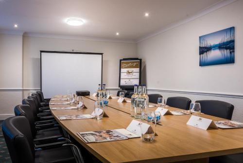 a conference room with a long table and chairs at Last Drop Village Hotel & Spa in Bolton