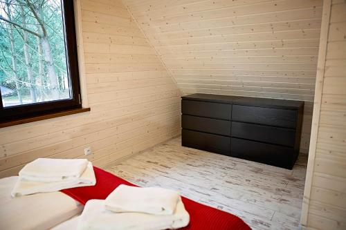 a room with two towels on a bed in a attic at Leśna Osada na Kaszubach - drewniane domy na wynajem in Bartoszylas