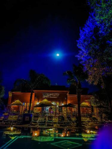 a building with tables and chairs at night at Le Relais De Marrakech in Marrakech