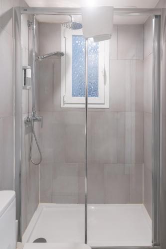 a bathroom with a shower and a window at Vibe Apartments by Olala Homes in Hospitalet de Llobregat