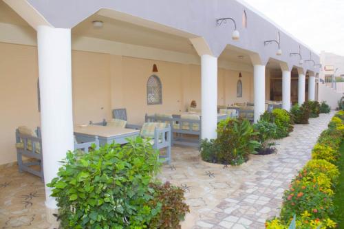 a patio with tables and chairs in a building at Janat Elsahara Hotel in Luxor