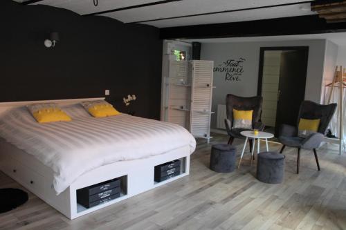 1 dormitorio con 1 cama, 2 sillas y mesa en Aux p'tits bonheurs la grange en Neuve-Chapelle