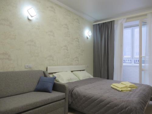 カリーニングラードにあるАпартаменты на Дадаеваのベッドルーム1室(ベッド1台、ソファ、窓付)