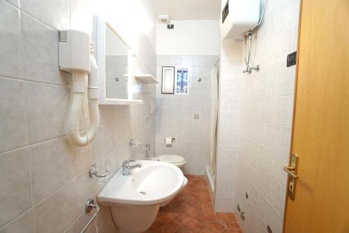 a white bathroom with a sink and a toilet at Agriturismo L'Acquabona in Rosignano Marittimo