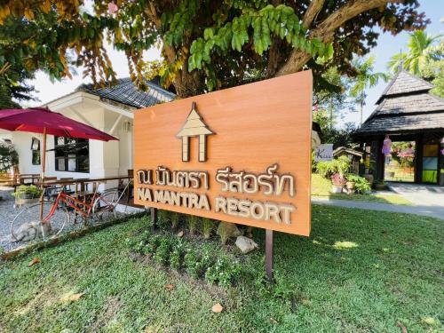 un panneau pour une station d'accueil dans une cour dans l'établissement Na Mantra Resort, à Chiang Mai