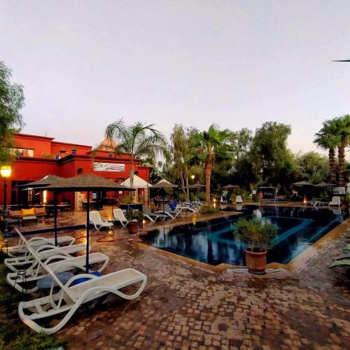 a swimming pool with lounge chairs and a resort at Le Relais De Marrakech in Marrakech