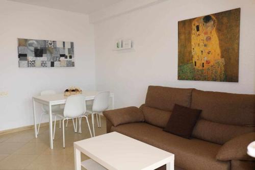 ein Wohnzimmer mit einem Sofa, einem Tisch und einem Gemälde in der Unterkunft 58 C Voramar apartamento 1 dormitorio in Calpe