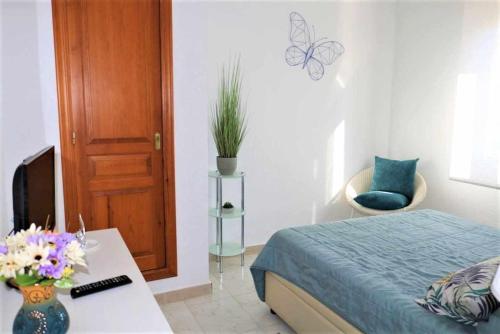 ein Schlafzimmer mit einem Bett und einem Tisch mit Blumen darauf in der Unterkunft 2G MAR II 1ª línea de playa con vistas al mar in Calpe