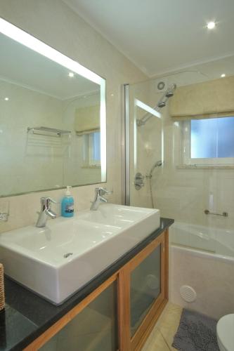 a bathroom with a white sink and a shower at Casa Monte Cristo Apartments - Orange in Lagos