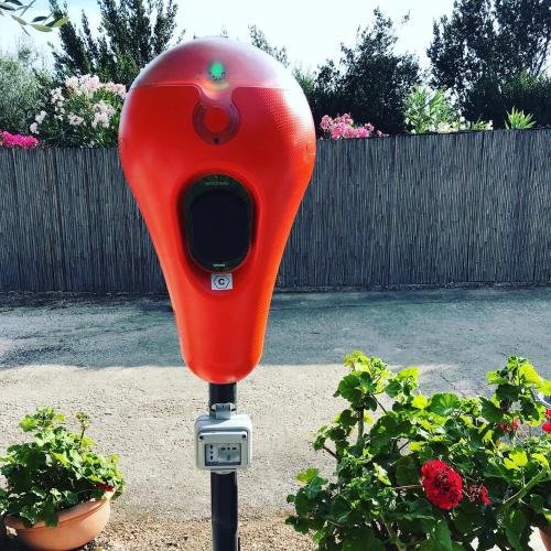 a red parking meter in front of some plants at Viestemare Resort & SPA in Vieste