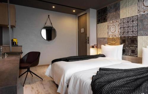 a bedroom with a large white bed and a chair at Brio Hotel in Kaohsiung