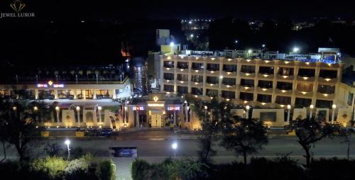 un grand bâtiment avec des lumières devant lui la nuit dans l'établissement Jewel Luxor Hotel, à Louxor