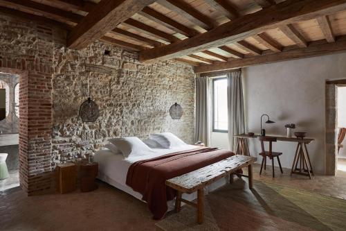 a bedroom with a bed and a brick wall at La Maison de Pommard in Pommard