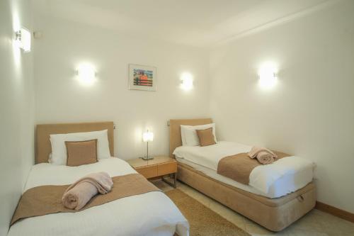 a bedroom with two beds with towels on them at Casa Monte Cristo Apartments - Almond in Lagos