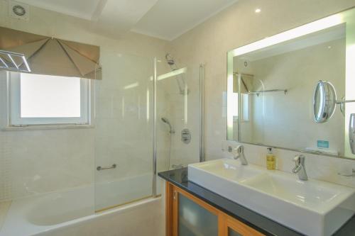 La salle de bains est pourvue d'un lavabo, d'une douche et d'un miroir. dans l'établissement Casa Monte Cristo Apartments - Almond, à Lagos