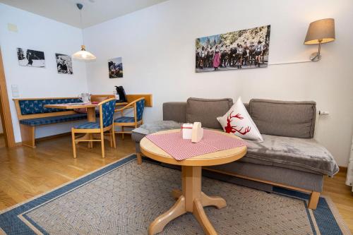 a living room with a couch and a table at Gemütliche Ferienwohnung Bergwiese, 2-Raum, separates Schlafzimmer, schönen Balkon oder Terrasse, Komfort Ausstattung, ruhige Südlage, kostenfrei WLAN und schöne helle Sauna, Brötchenservice, Parkplatz, Hunde auf Anfrage, E-Tankstelle, Sonnenlage in Balderschwang