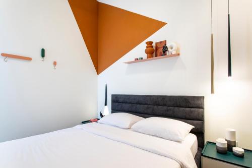 a bedroom with a bed with white sheets at De Pejoto in Tel Aviv