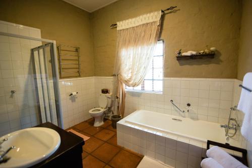 a bathroom with a tub and a toilet and a sink at Downstream in Dullstroom