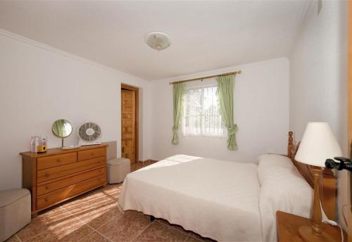 a bedroom with a bed and a dresser and a window at La Casa Del Sol in Torrevieja