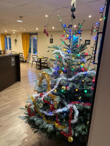 a christmas tree sitting in the middle of a room at Hôtel inn design Sancé in Mâcon