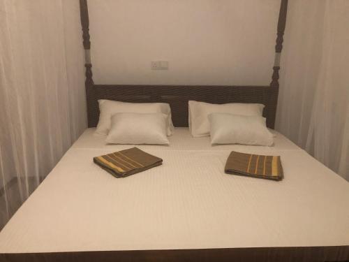 a bed with two brown and white pillows on it at Summer Time Hiriketiya in Dickwella