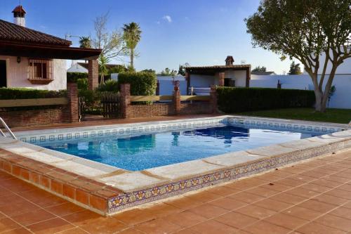 una piscina en un patio junto a una casa en Fuente del Gallo Nomada, en Conil de la Frontera