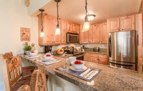 a kitchen with wooden cabinets and a stainless steel refrigerator at Courchevel 14 Remodeled Light and Bright Mountain Cabin, Walk to Canyon Lodge Slopes in Mammoth Lakes