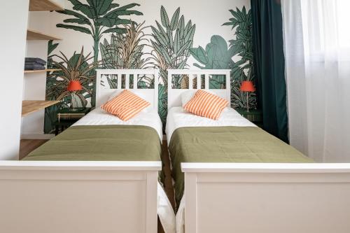 two beds in a room with plants on the wall at La Fée - jolie maison avec jardin - plage à 700 m in Dinard