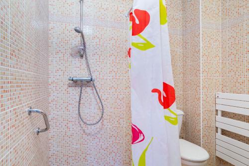 a bathroom with a shower with a toilet and a shower curtain at Les Voiles - appartement avec terrasse - plage à 50 m in Pléneuf-Val-André