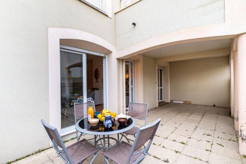 un patio avec une table et des chaises sur un patio dans l'établissement Les Voiles - appartement avec terrasse - plage à 50 m, à Pléneuf-Val-André