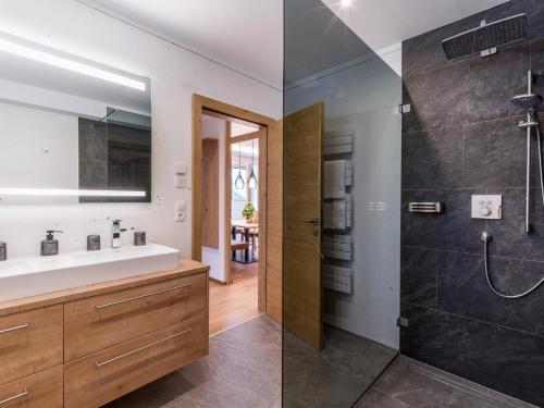 2 imágenes de un baño con lavabo y ducha en Apart Painting, en Ried im Zillertal