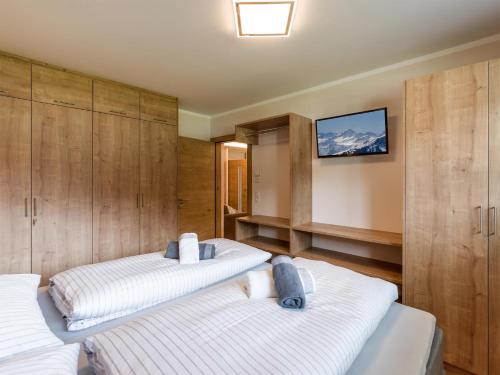 1 dormitorio con 2 camas y TV en la pared en Apart Painting, en Ried im Zillertal