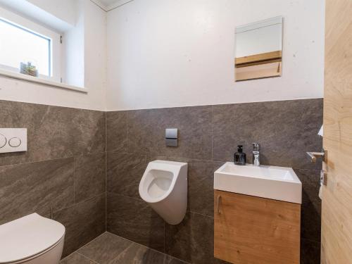 a bathroom with a toilet and a sink and a urinal at Apart Painting in Ried im Zillertal