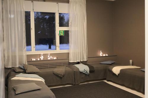 a room with two beds in front of a window at Ruva Holidays in Kuusamo