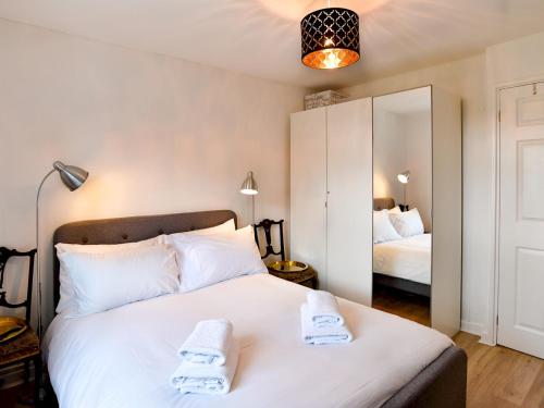 - une chambre avec un grand lit blanc et des serviettes dans l'établissement Pass The Keys Quiet Coastal Retreat inbetween Langland & Caswell, à Swansea