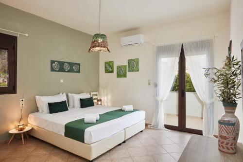 a bedroom with a large bed and a large window at Villa Elodia with Pool & Garden in Heart of Crete in Avdhellás