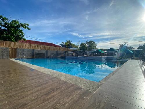 a swimming pool with blue water and a wooden deck at Hip Nautic Beach Resort powered by Cocotel in Lian