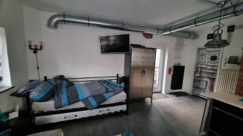 1 dormitorio con 1 cama y TV en la pared en Kohle und Stahl en Hattingen
