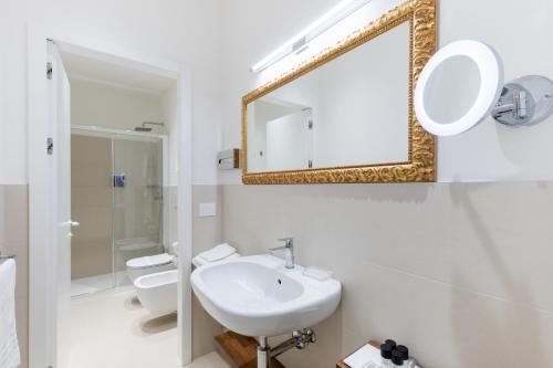 a white bathroom with a sink and a mirror at Oriana Homèl Udine in Udine