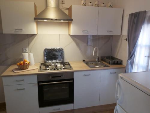 a kitchen with white cabinets and a stove top oven at Kuća za odmor Tupek in Zagreb