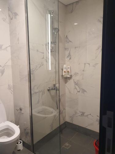 a bathroom with a glass shower with a toilet at Cozy 1-bedroom apartment in Dubai South with Pool in Dubai